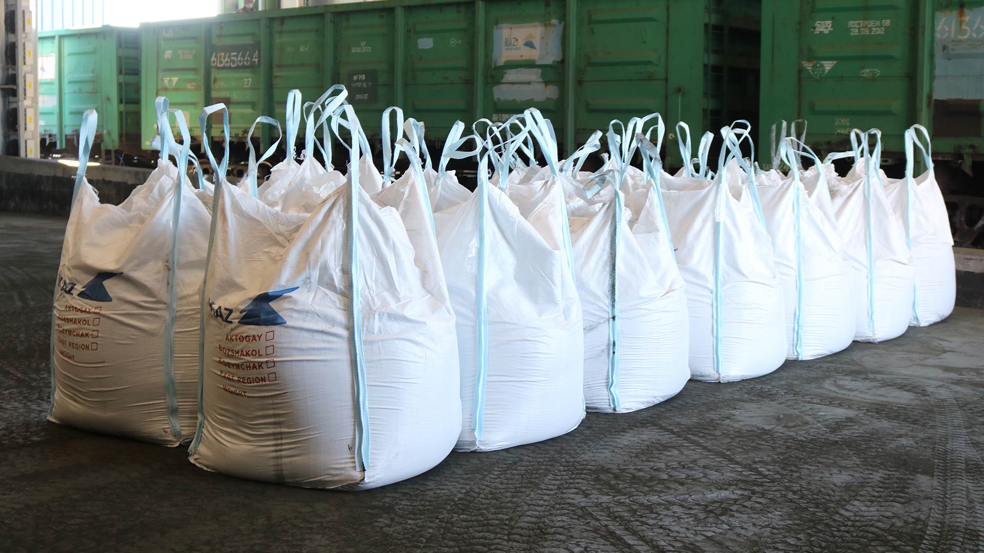 Two rows of seven white industrial size bags filled with unspecified materials.