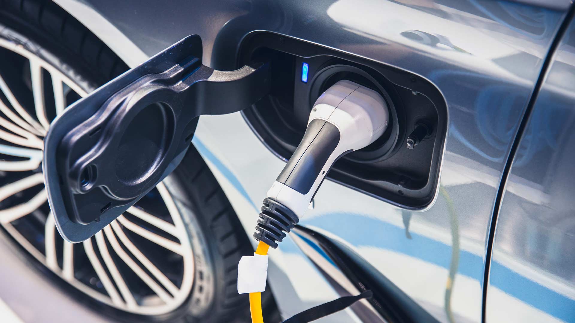 Close up shot of an EV charger inserted into charging port of an electric vehicle. 