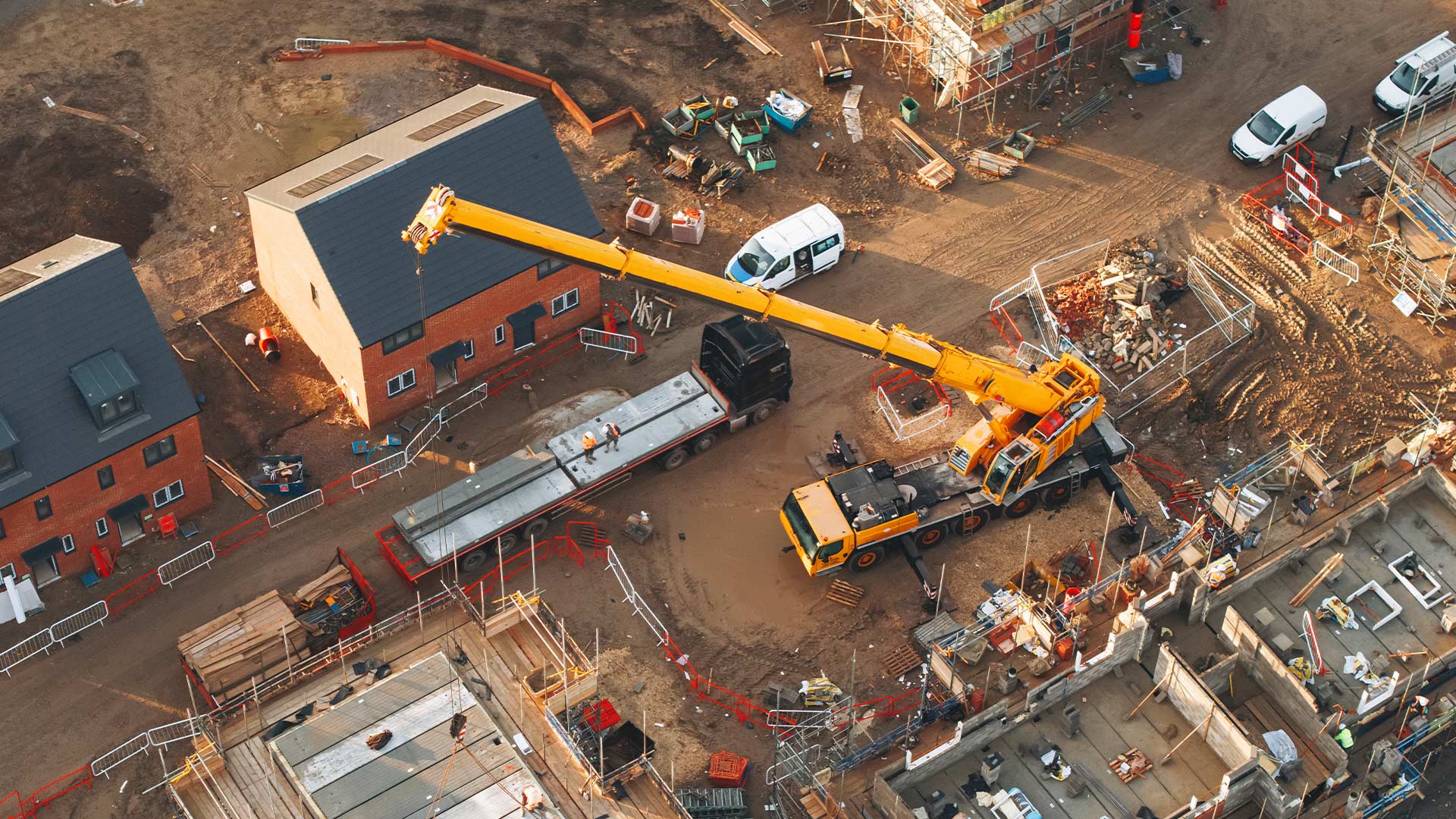 Aerial birdseye view of an unfinished housing development. Construction is taking place with machinery visible. 