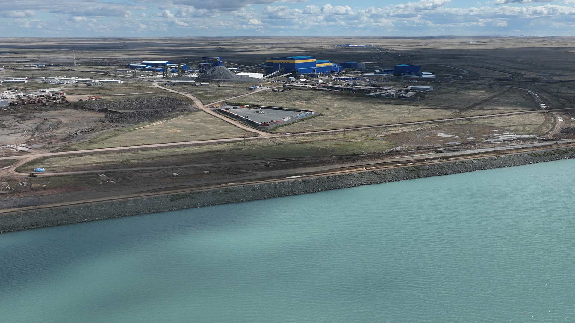 Body of water with land and low cloud in the distance.